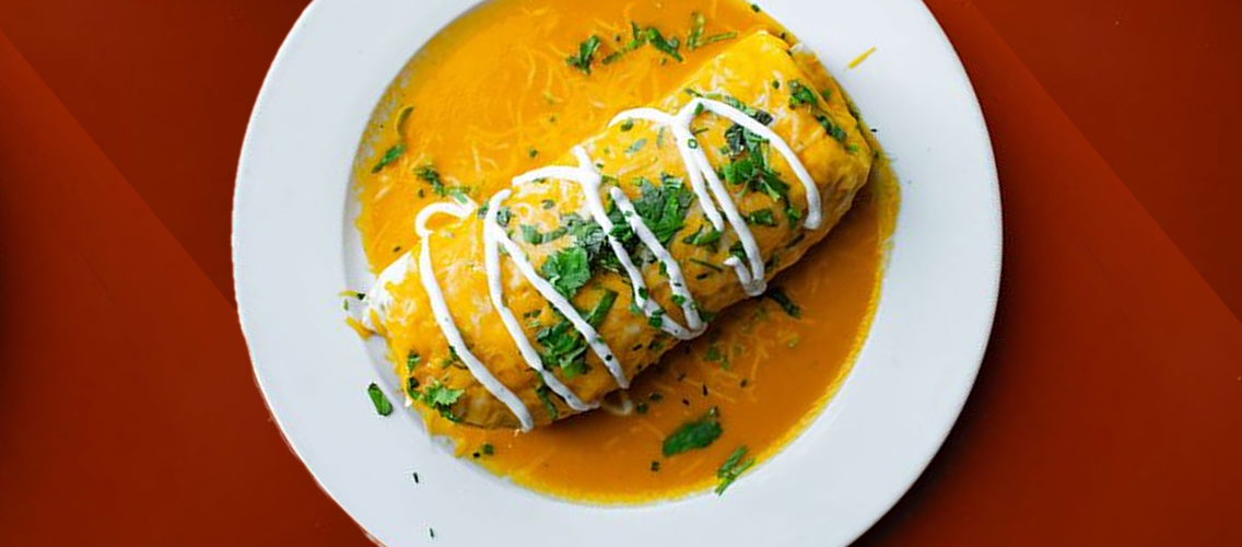 a photo of a four tortilla burrito with yellow habanero sauce on top on a white plate